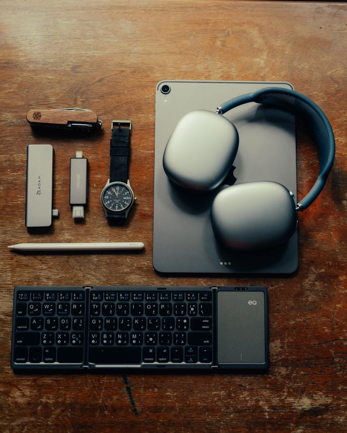 Collection of modern gadgets and accessories arranged on a wooden desk.